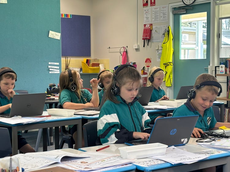 students with headphones on working on laptops