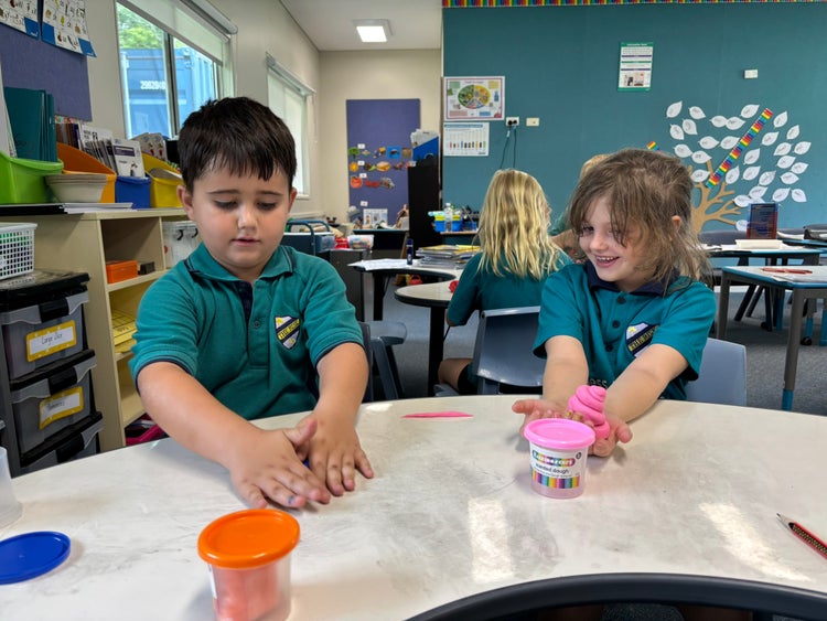 a boy and girl student playing with modeling clay