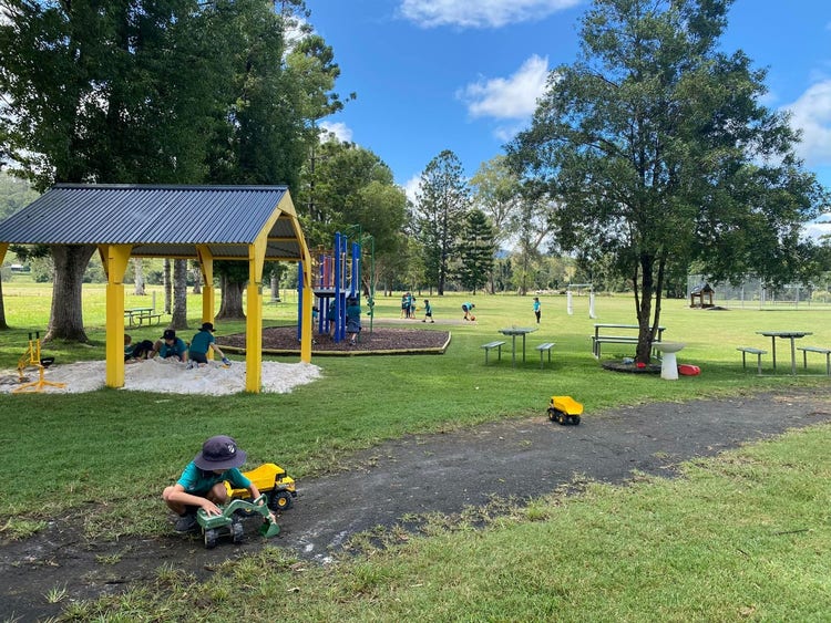 wide shot of students playing in the sandpit and on playground